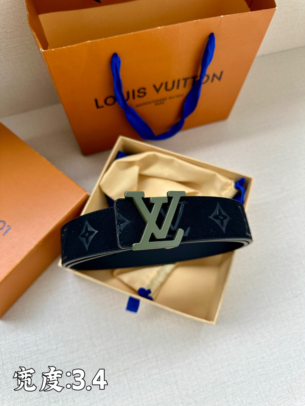 Louis Vuitton belt, dark navy monogram strap with large silver LV buckle.