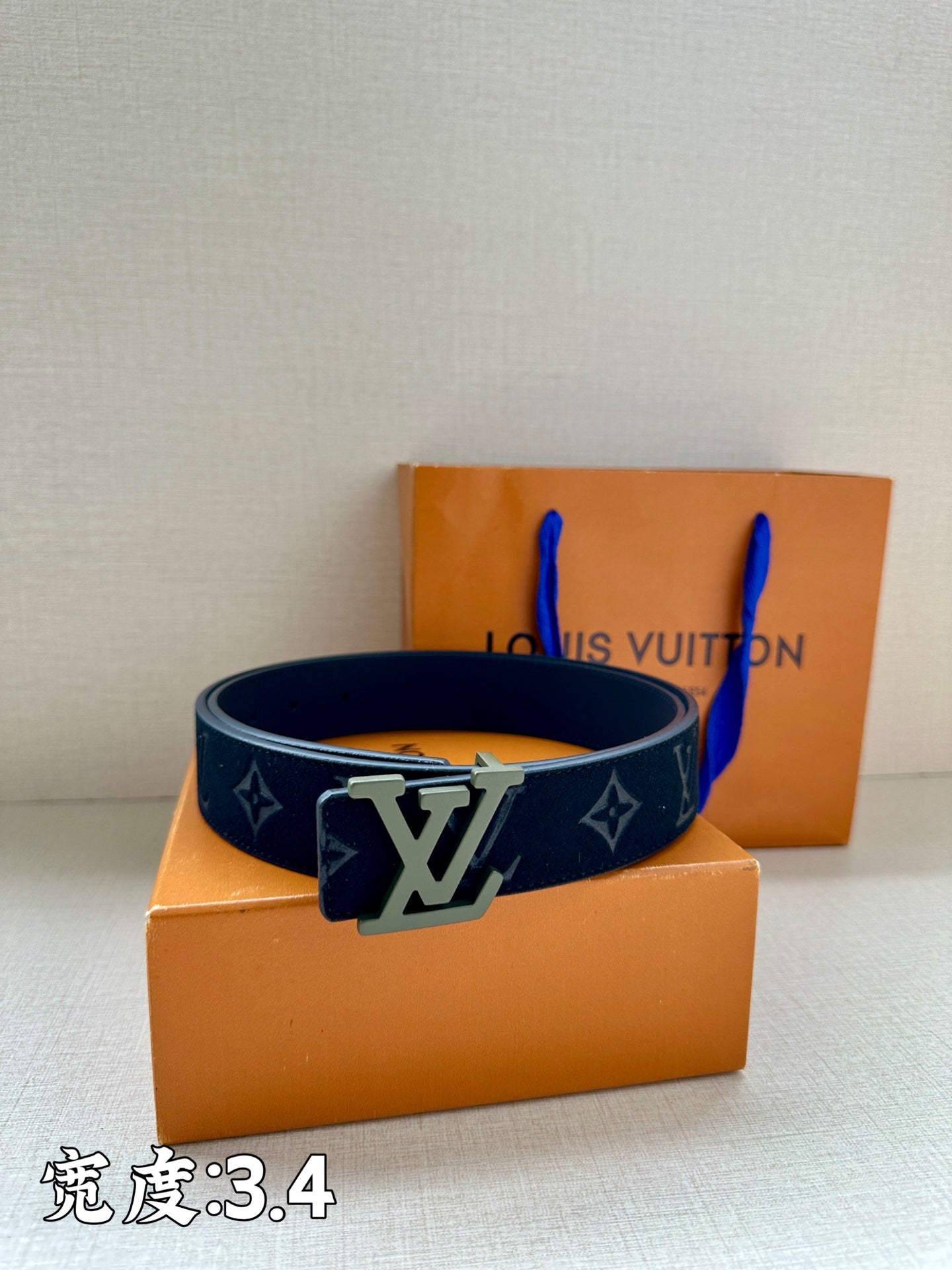 Louis Vuitton belt, dark navy monogram strap with silver LV buckle.