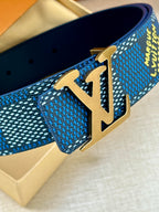 Close-up of gold-tone LV buckle on blue Louis Vuitton belt with textured pattern.