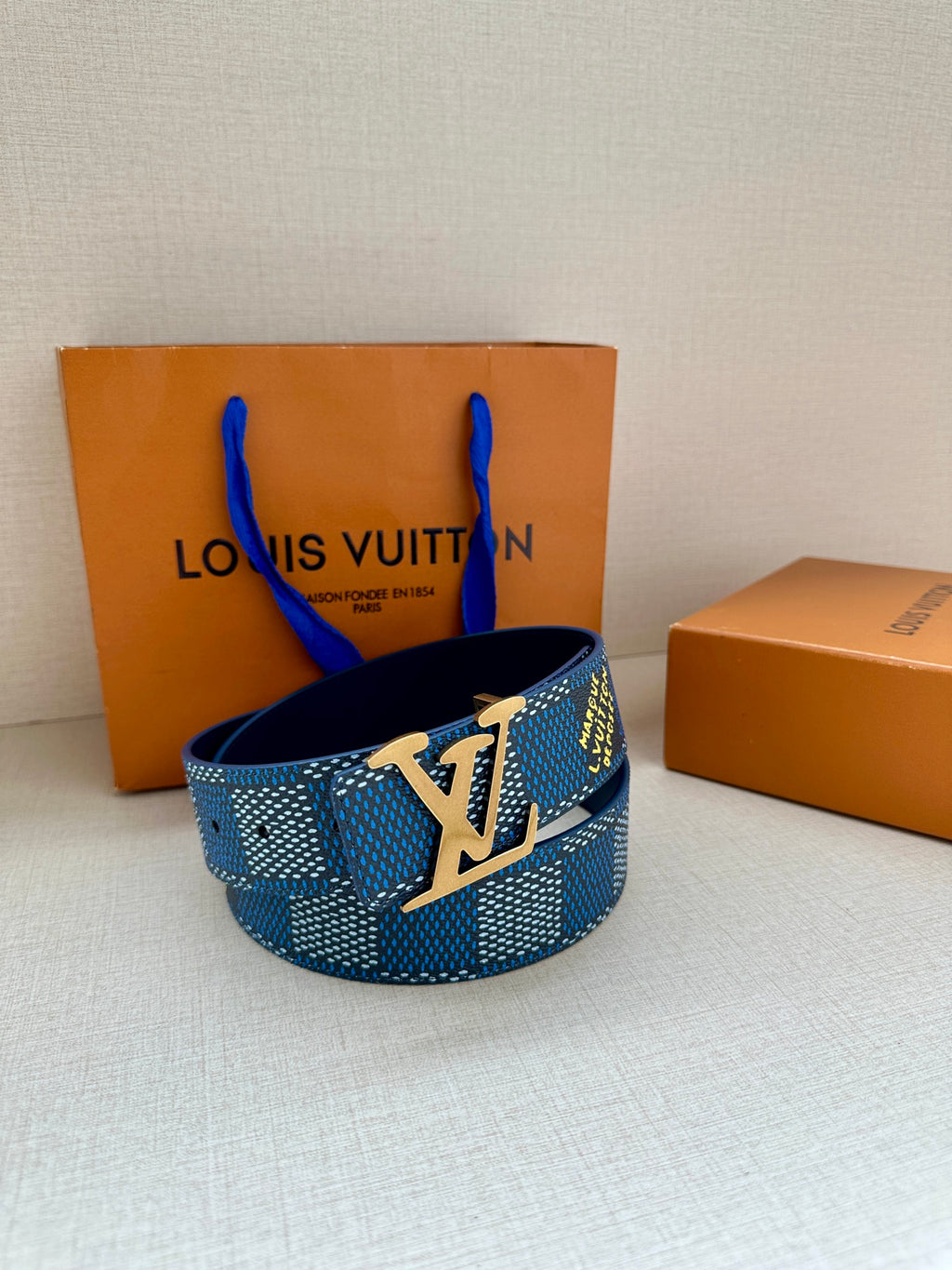 Blue Louis Vuitton belt with LV logo buckle and dark blue inner strap.