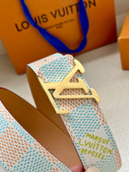 Louis Vuitton belt close-up: pastel blue patterned strap with gold LV buckle.