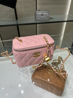 Pink quilted Chanel crossbody bag with gold chain and front zipper; brown pouch nearby