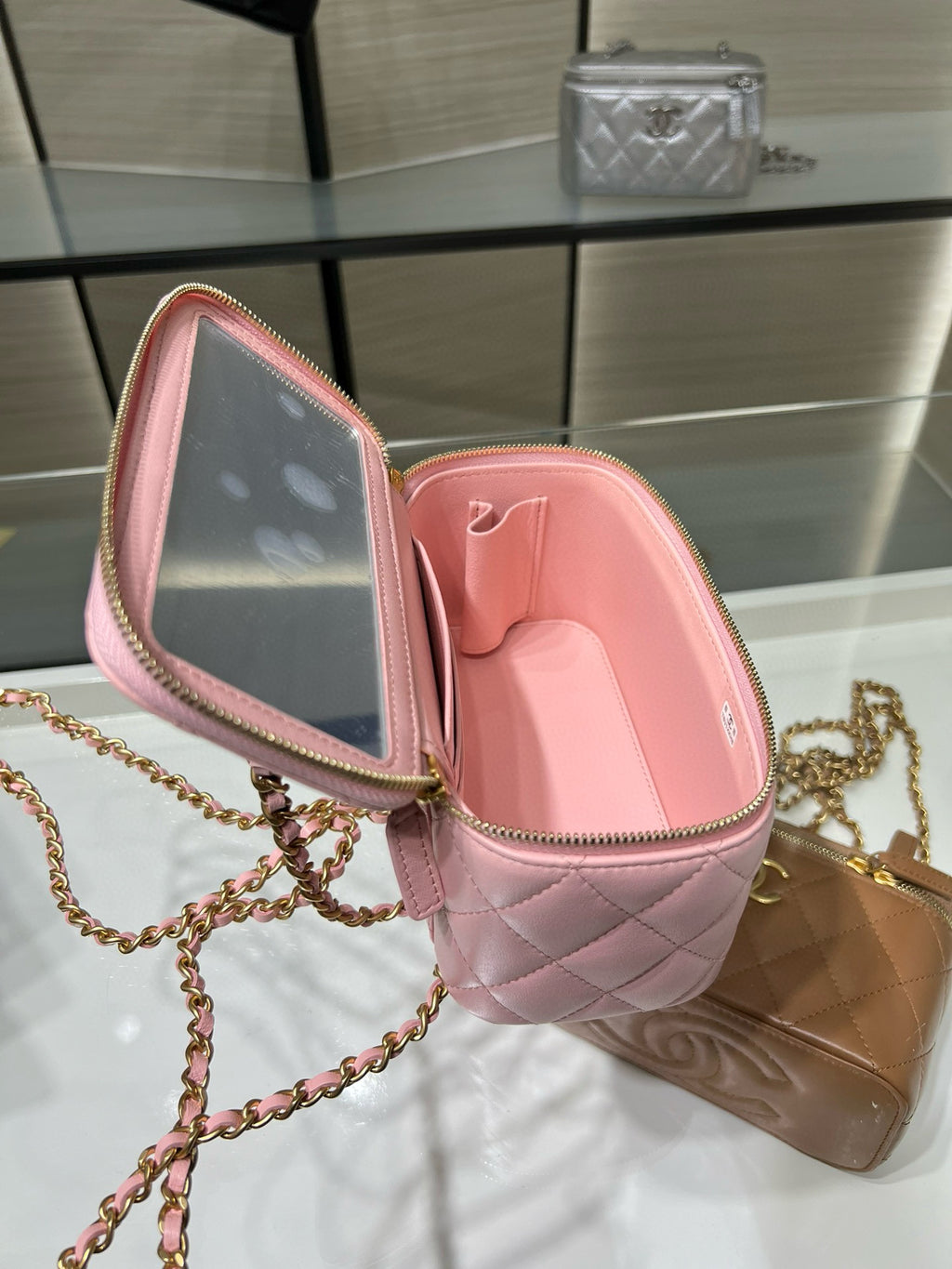 Pink Chanel mini bag open view with quilted leather interior and gold zipper