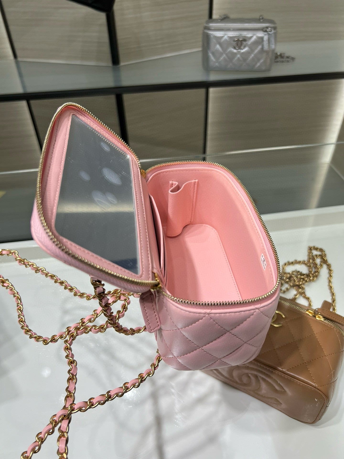 Pink Chanel mini bag open view with quilted leather interior and gold zipper