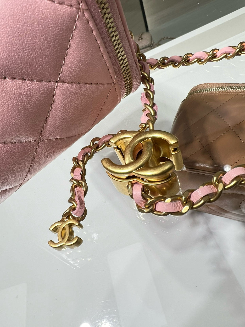 Pink Chanel bag close-up with gold chain hardware and CC logo charm