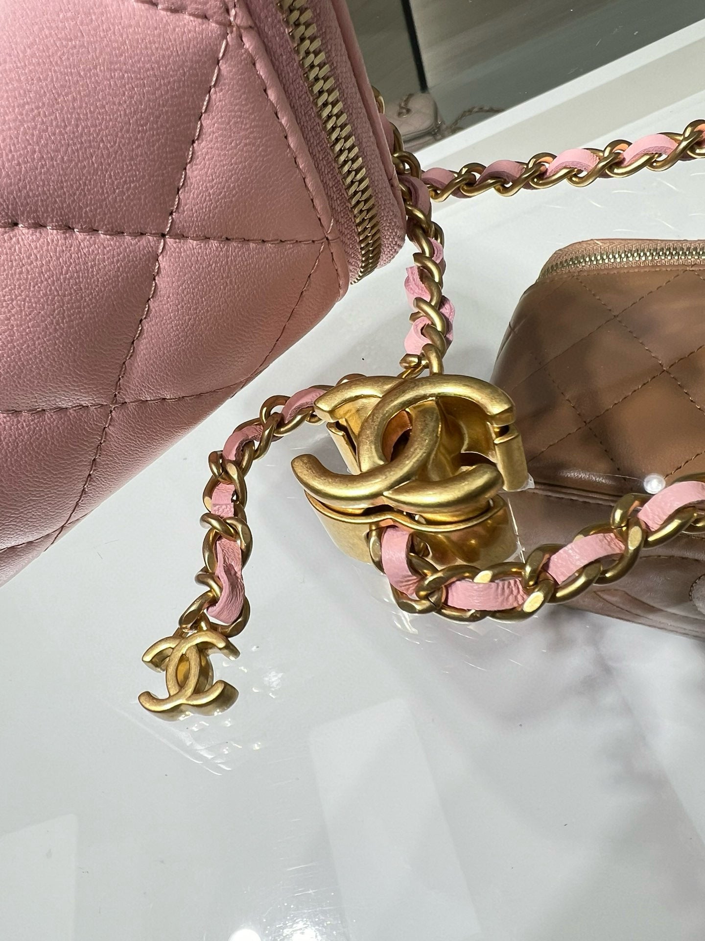Pink Chanel bag close-up with gold chain hardware and CC logo charm