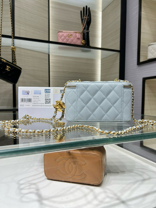 Light blue quilted crossbody bag with gold-tone chain and front logo charm