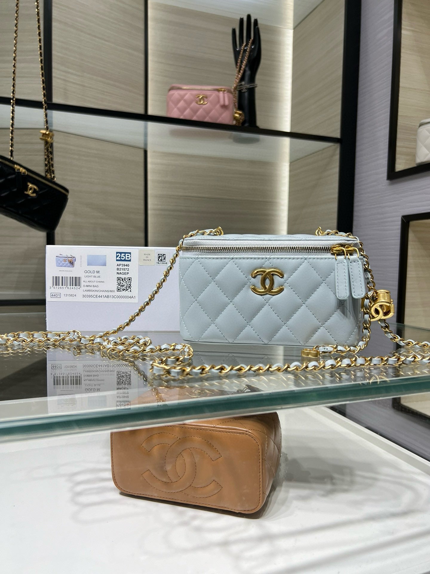 Light blue quilted crossbody bag with gold-tone chain and logo medallion
