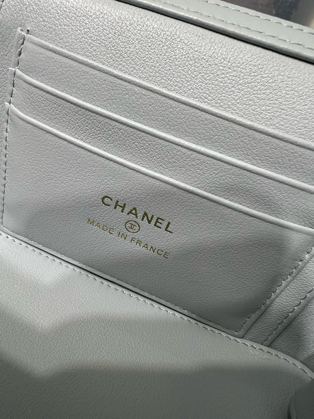 Light blue interior logo label reading CHANEL on quilted bag lining
