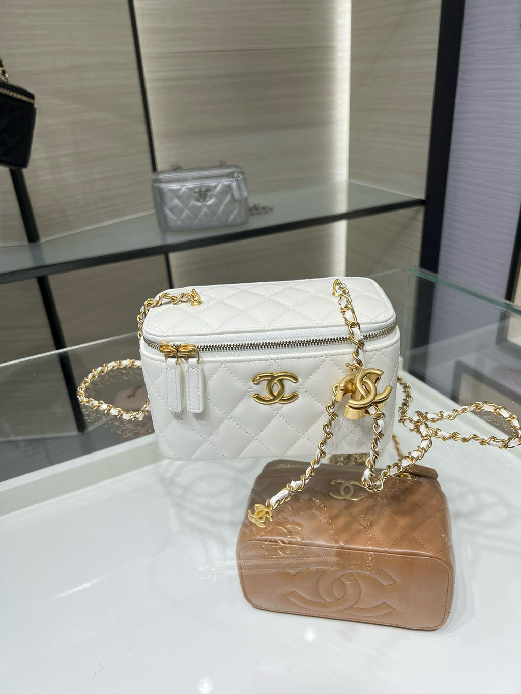 White quilted crossbody bag with gold-tone chain strap and zip-top closure