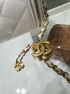 Close-up of gold-tone chain and CC-style charm on white quilted bag