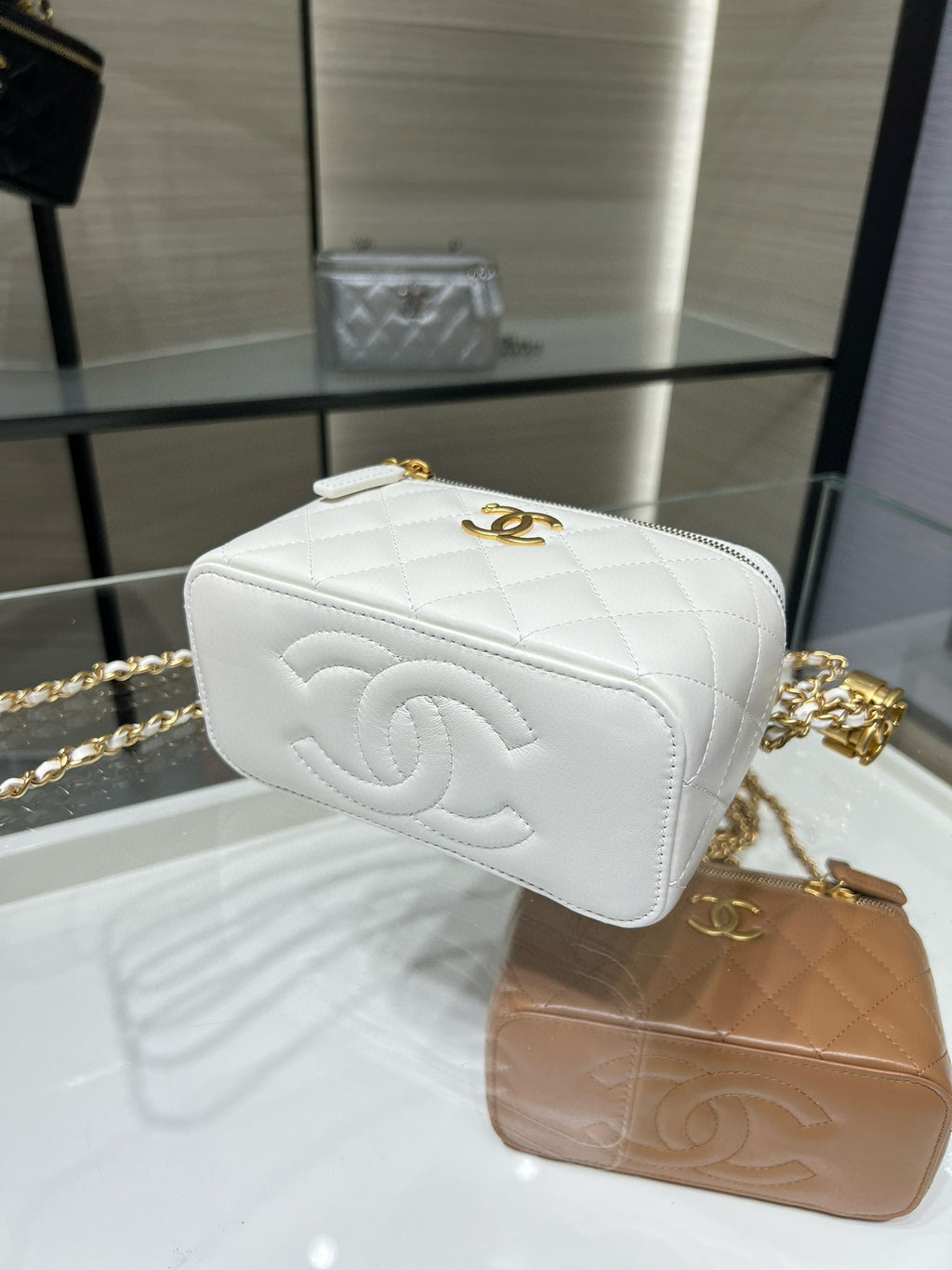 White quilted mini bag with embossed CC-style emblem and gold-tone chain strap