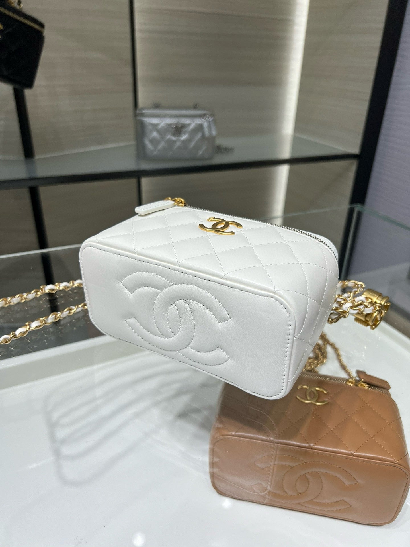 White quilted mini bag with embossed CC-style emblem and gold-tone chain strap