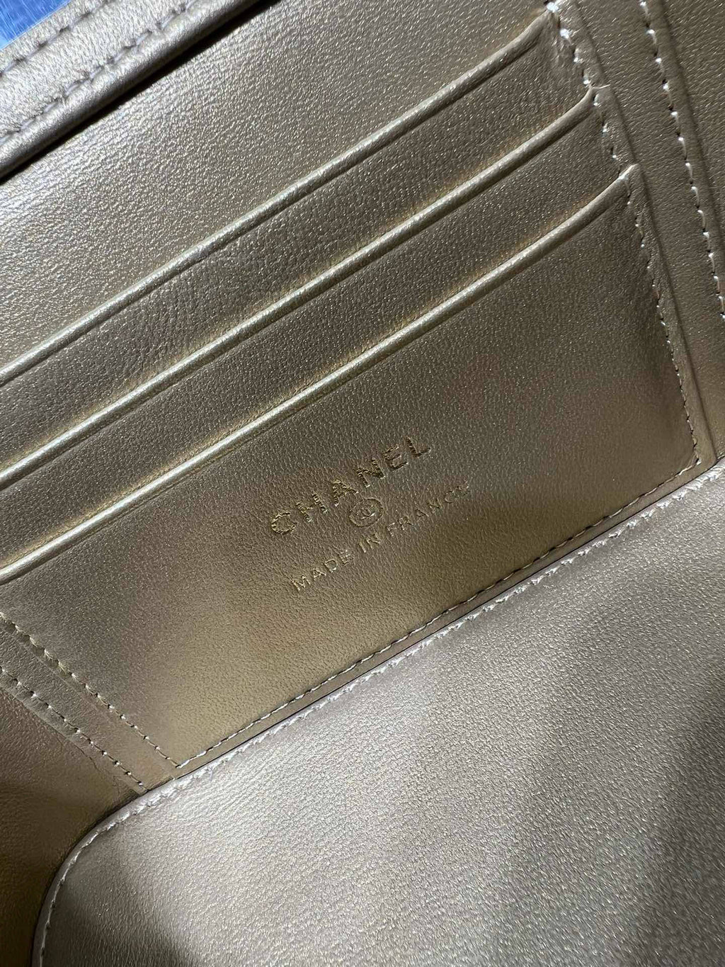Close-up of bag interior lining with embossed Chanel name and monogram on tan leather