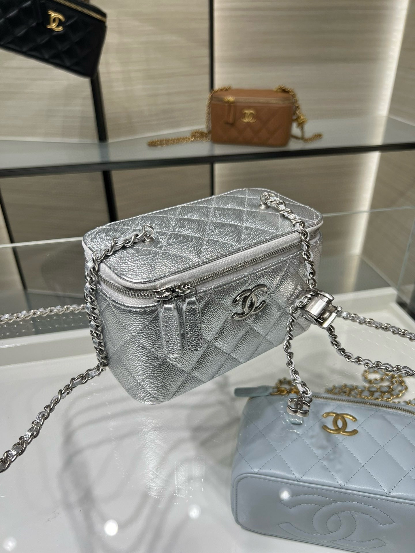 Chanel quilted mini bag, silver-tone with chain strap, front flap and zipper detail.