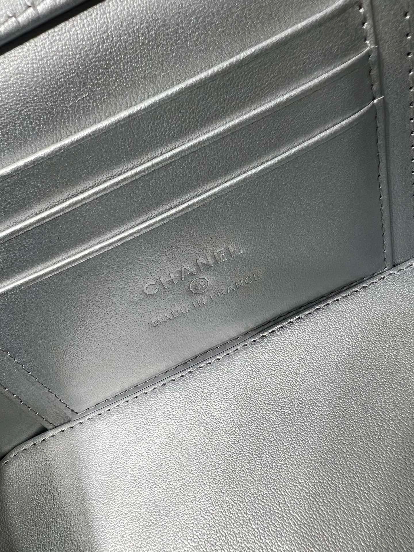 Chanel embossed on silver-tone leather flap with stitched edge and textured grain.