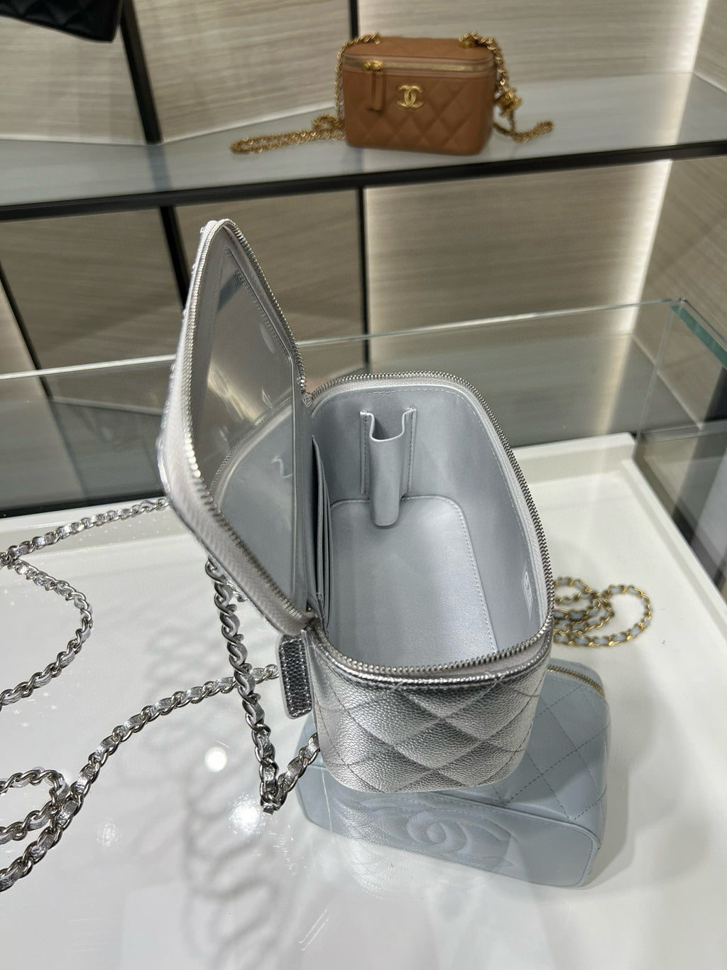 Chanel quilted mini crossbody bag, silver-tone open showing inner pocket and zipper.