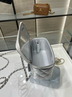 Chanel silver mini bag open with clasp, quilted texture, and chain strap