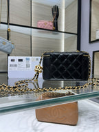 Chanel quilted mini bag with gold chain, top handle, and CC logo on dark leather