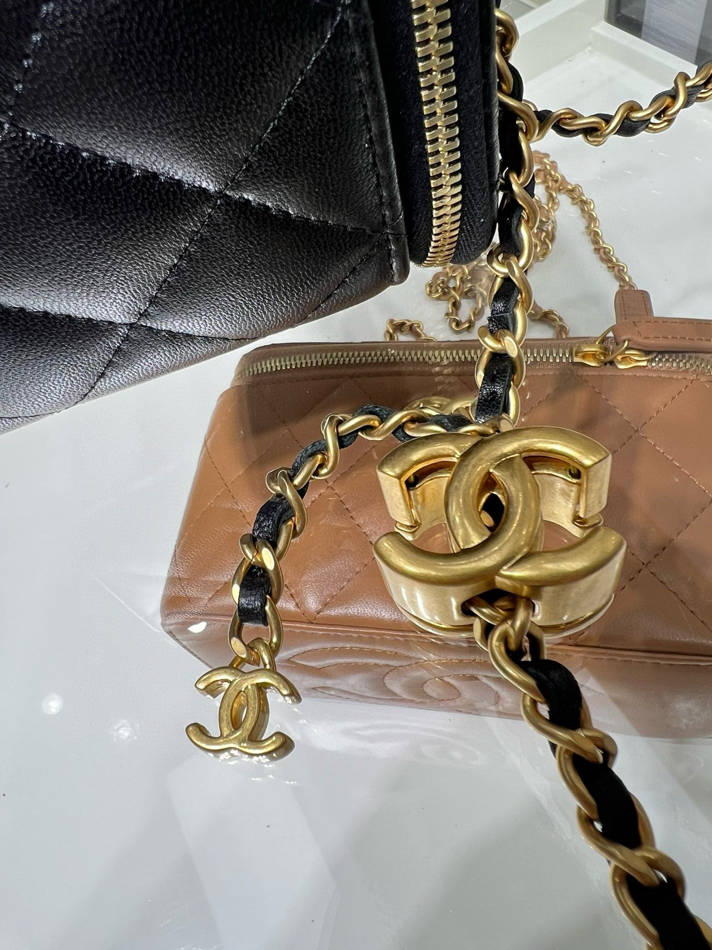 Chanel bag close-up with gold chain, gold hardware, and quilted black leather edge