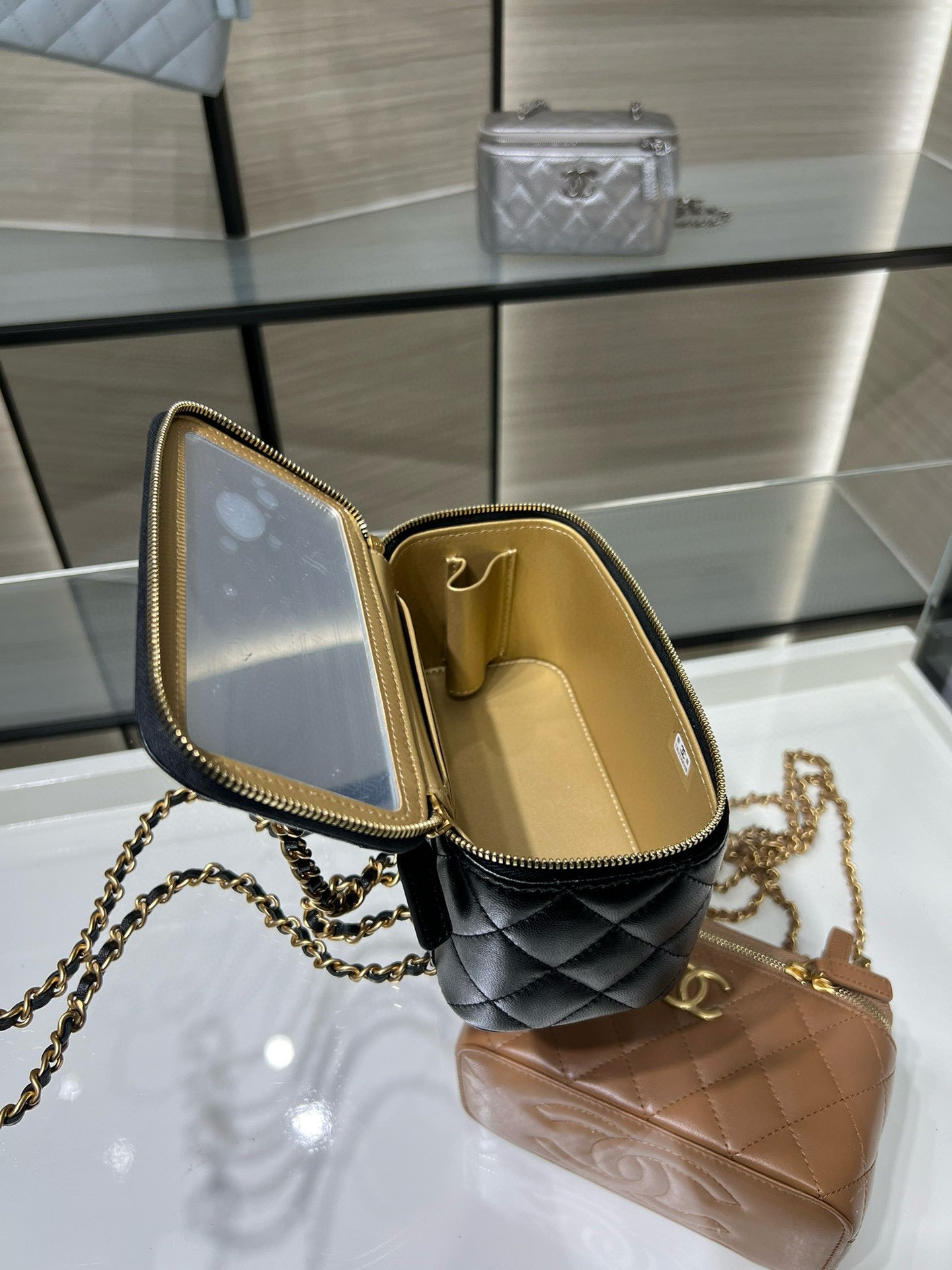 Chanel mini bag open with beige interior lining, gold zipper edge, black exterior
