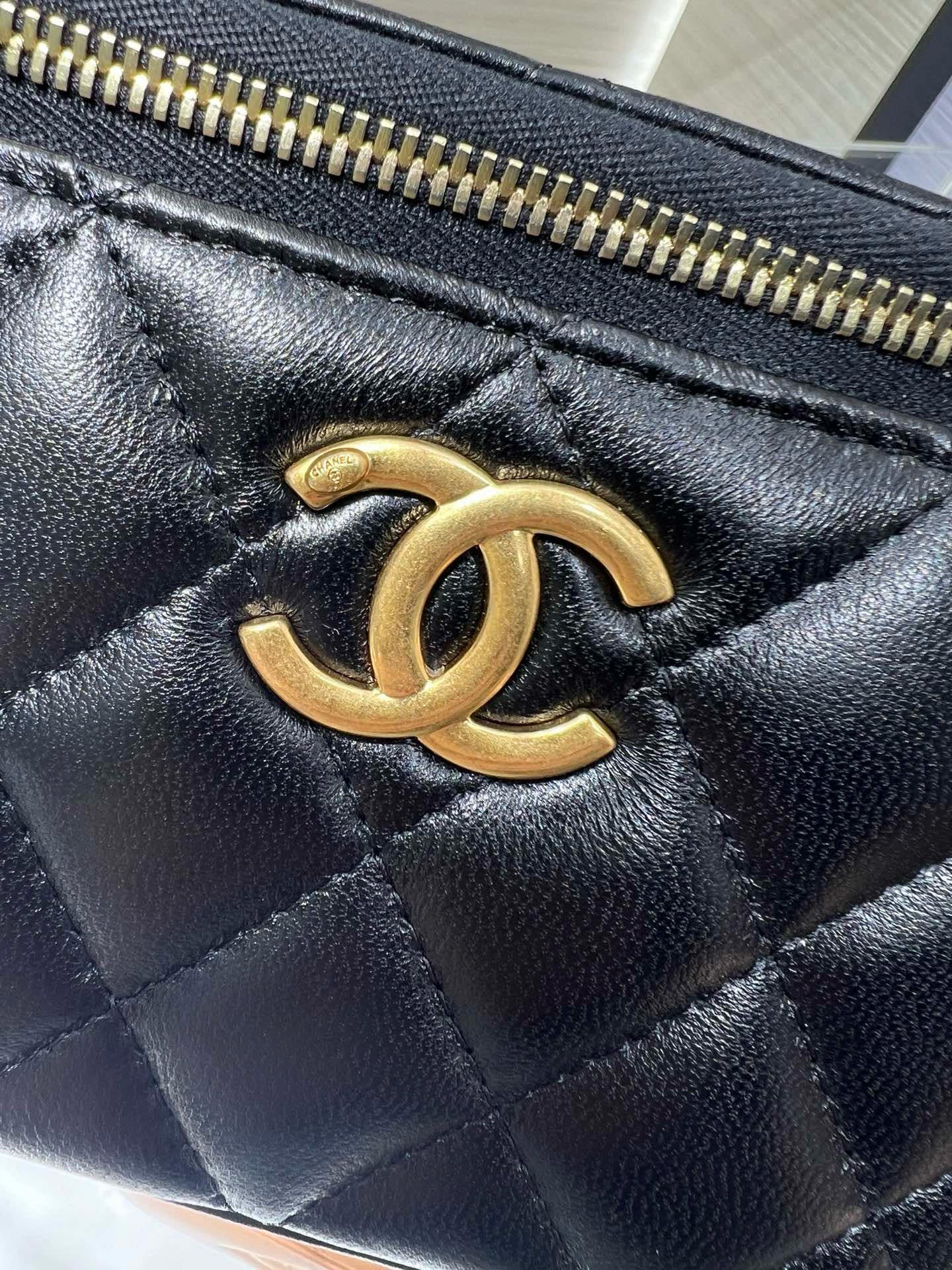 Chanel CC logo on black quilted leather bag with gold-tone zipper trim