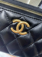 Chanel CC logo on dark quilted leather mini bag with gold zipper hardware
