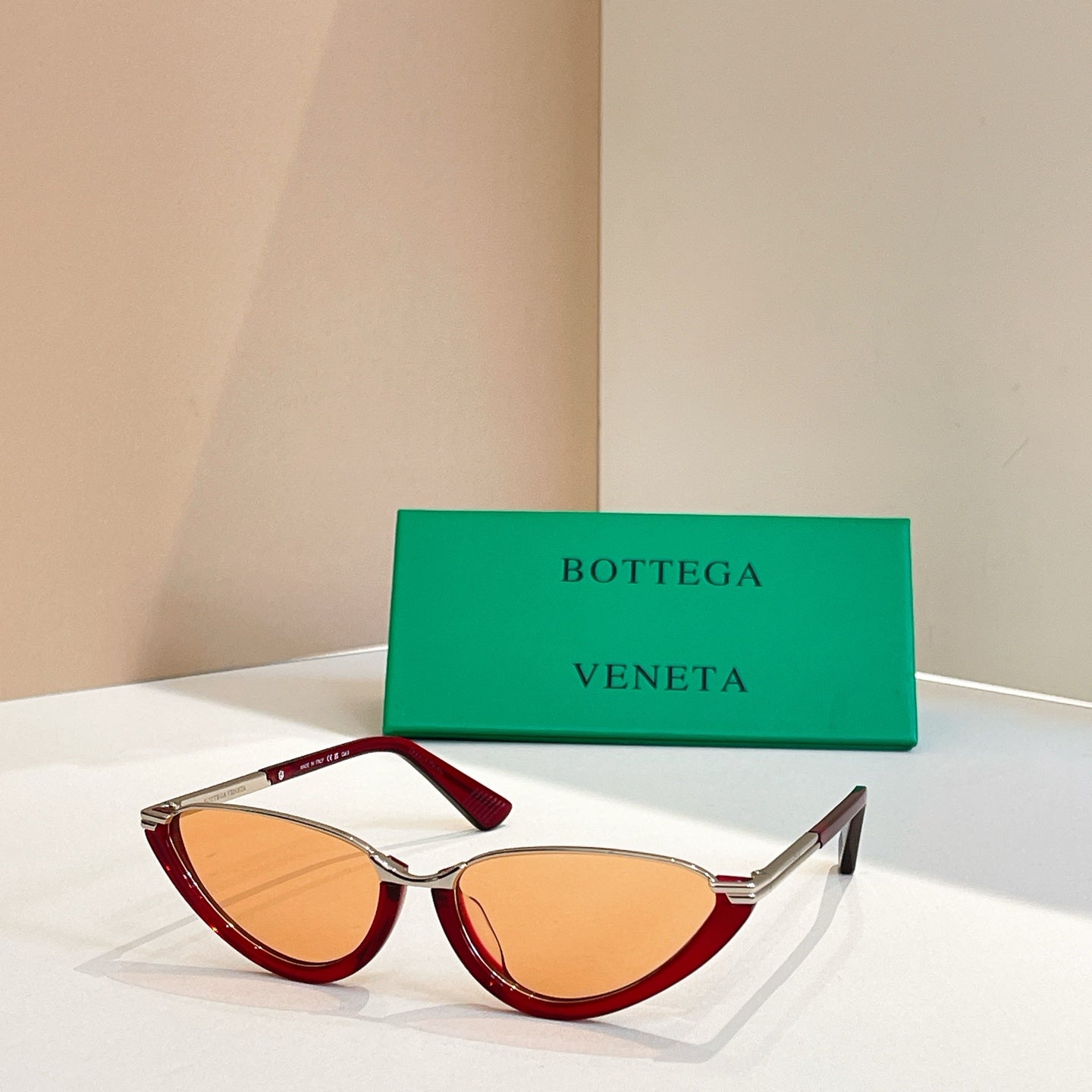 Bottega Veneta cat-eye sunglasses with amber lenses and red translucent frames