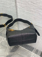 Black quilted hobo bag with wide top, curved handles, and side zipper pulls