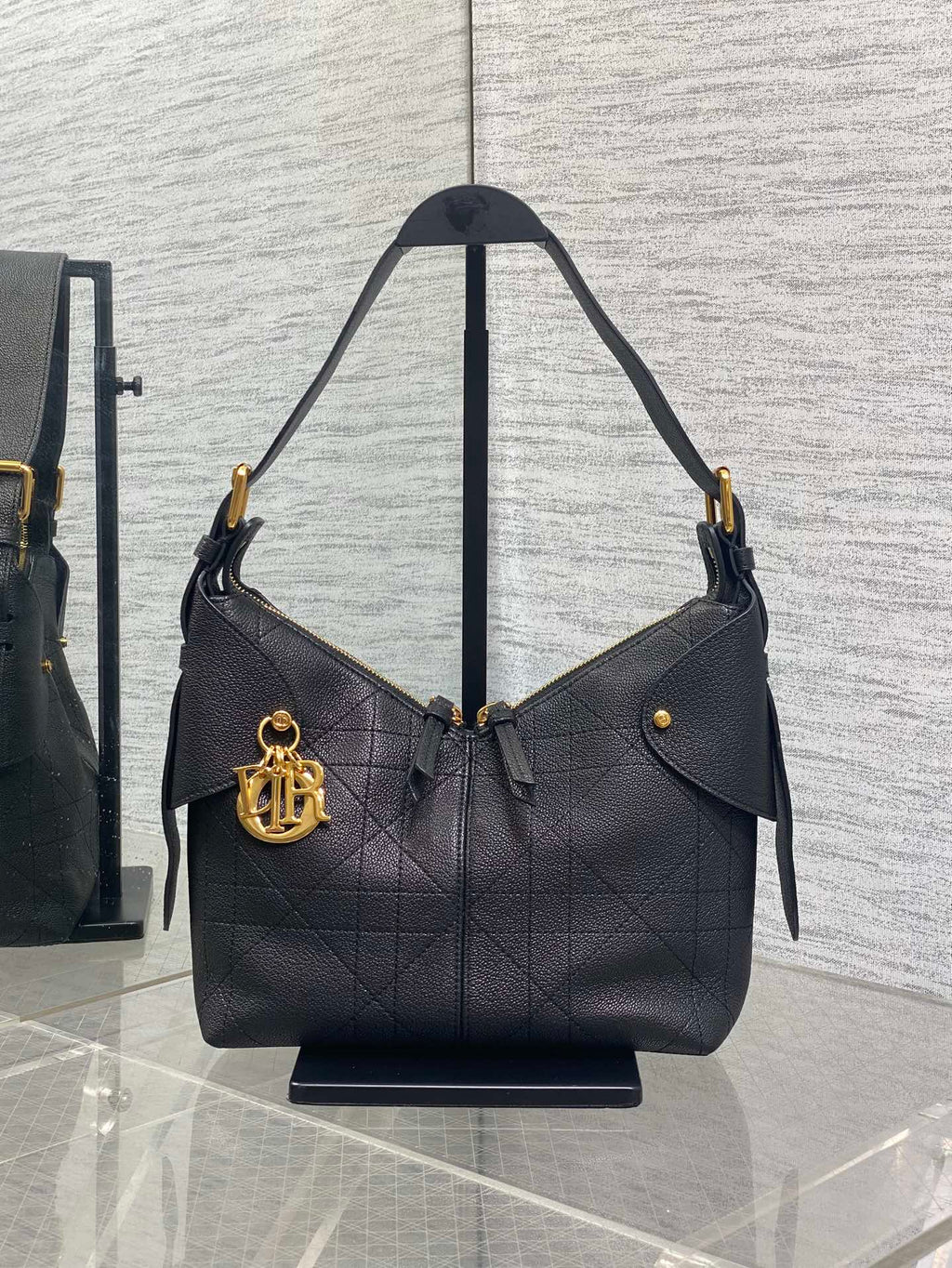 Black quilted leather shoulder bag with curved handles and gold-tone hardware