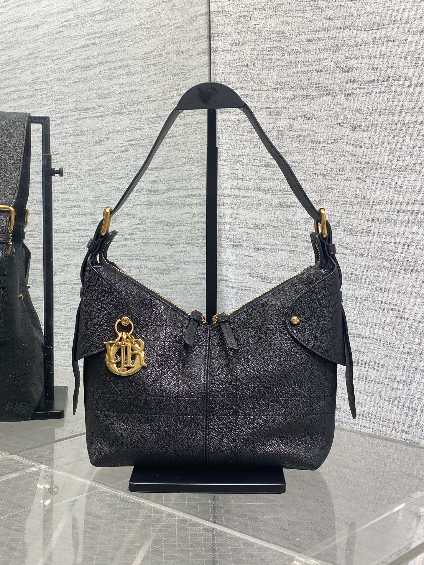 Black quilted leather shoulder bag with curved handles and gold-tone hardware