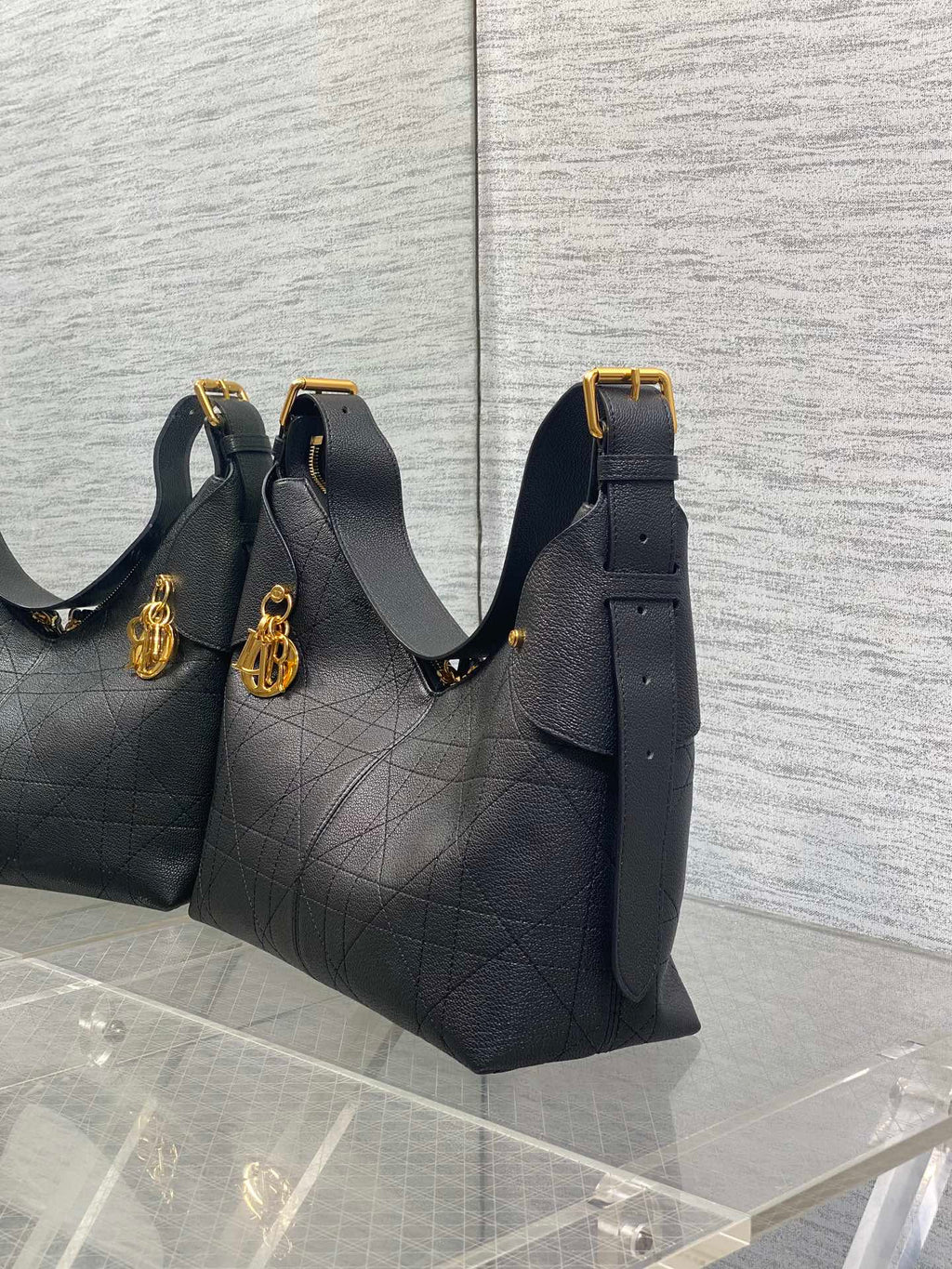 Dior quilted hobo bag with gold charm and shoulder straps, dark