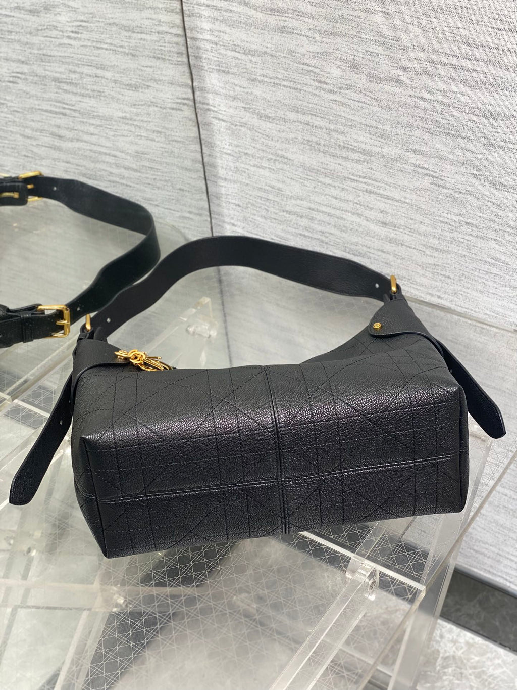 Dior quilted hobo bag with curved top handle and gold accents, dark