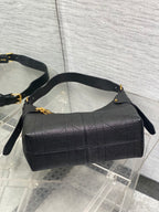 Dior quilted hobo bag with curved top handle and gold accents, dark