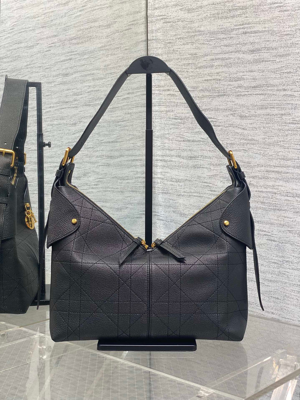 Dior quilted hobo bag with gold-tone hardware, angled shoulder straps, dark
