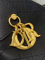 Dior gold-tone CD charm on dark quilted leather bag