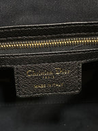 Dior bag label with gold text on dark leather