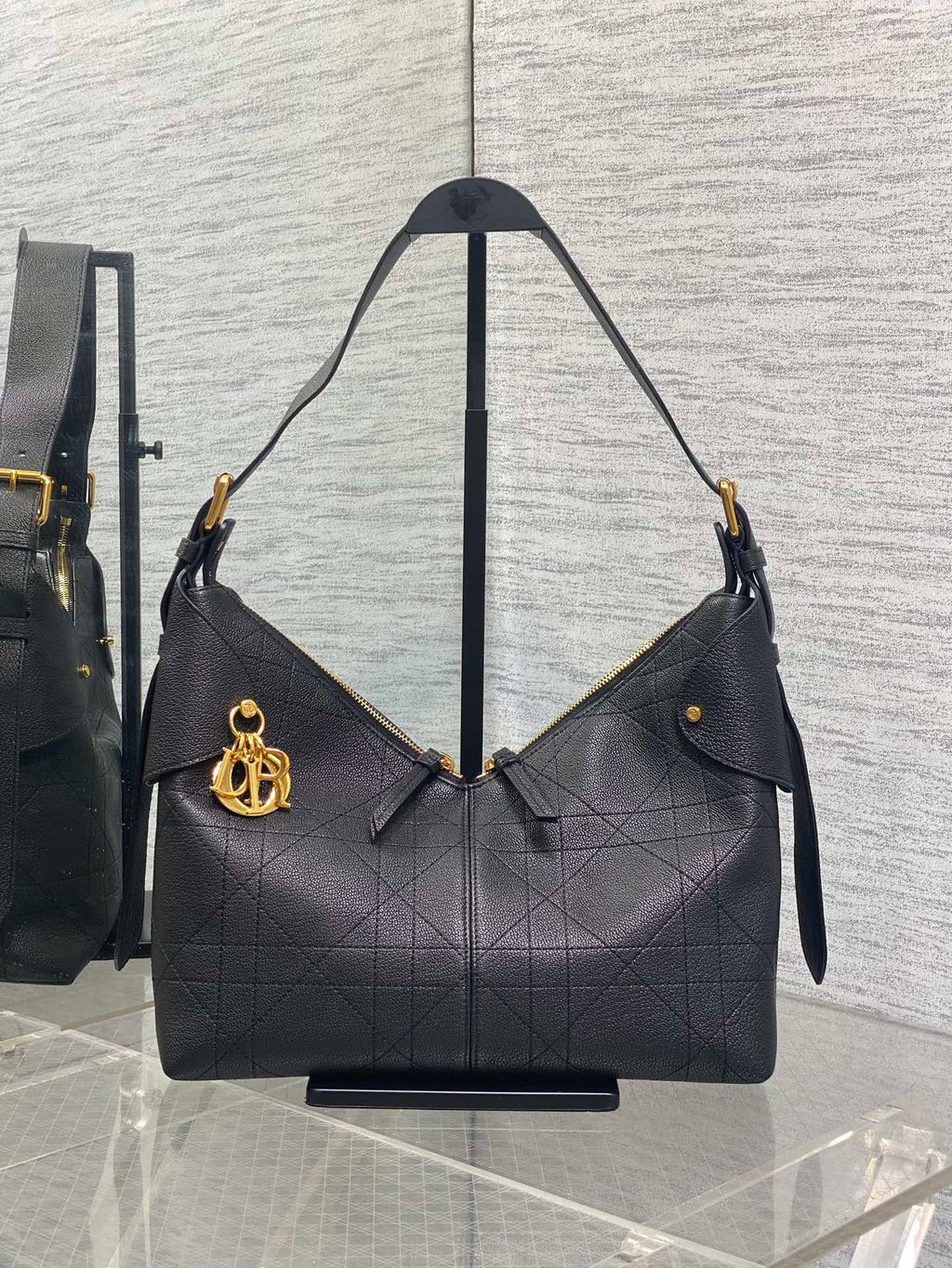 Dior quilted hobo bag with gold-tone hardware and shoulder straps, dark