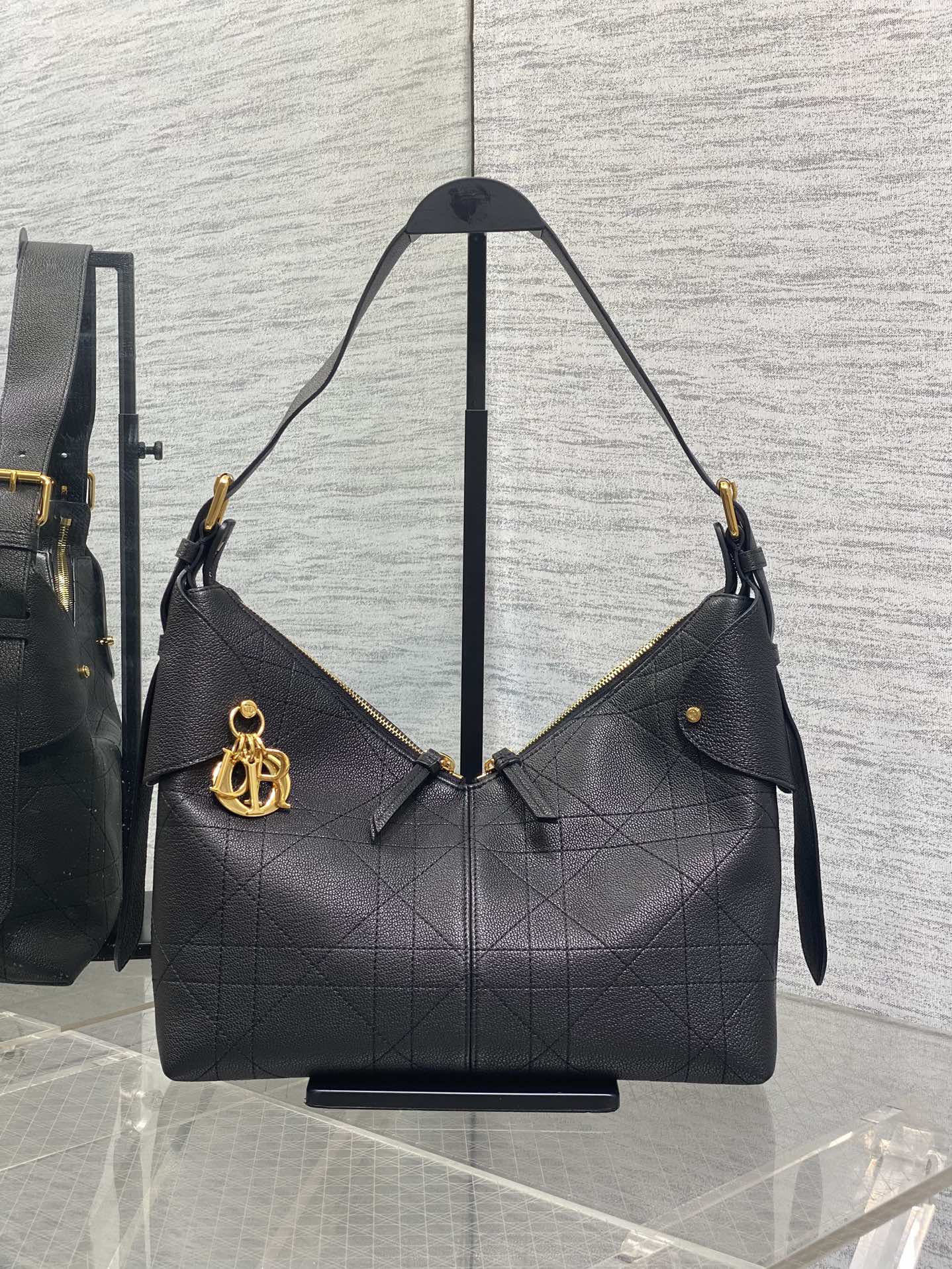 Dior quilted hobo bag with gold-tone hardware and shoulder straps, dark