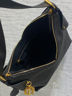 Dior hobo bag interior with dark lining and gold zipper closure, dark