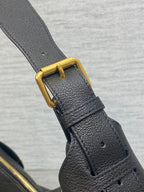 Dior leather shoulder strap with gold buckle and stitching on dark bag