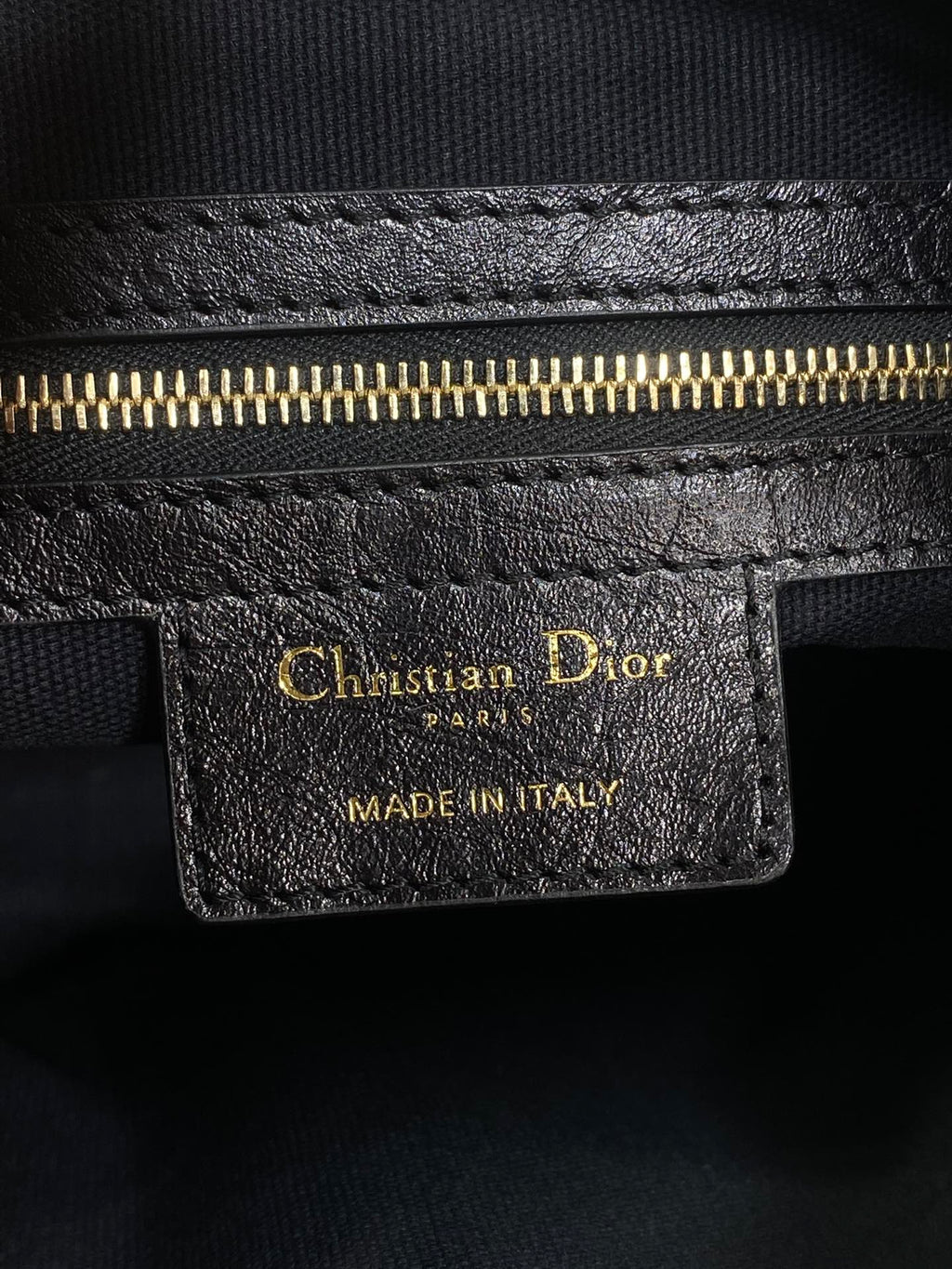 Black leather Dior tag with gold lettering and 'MADE IN ITALY' stamp