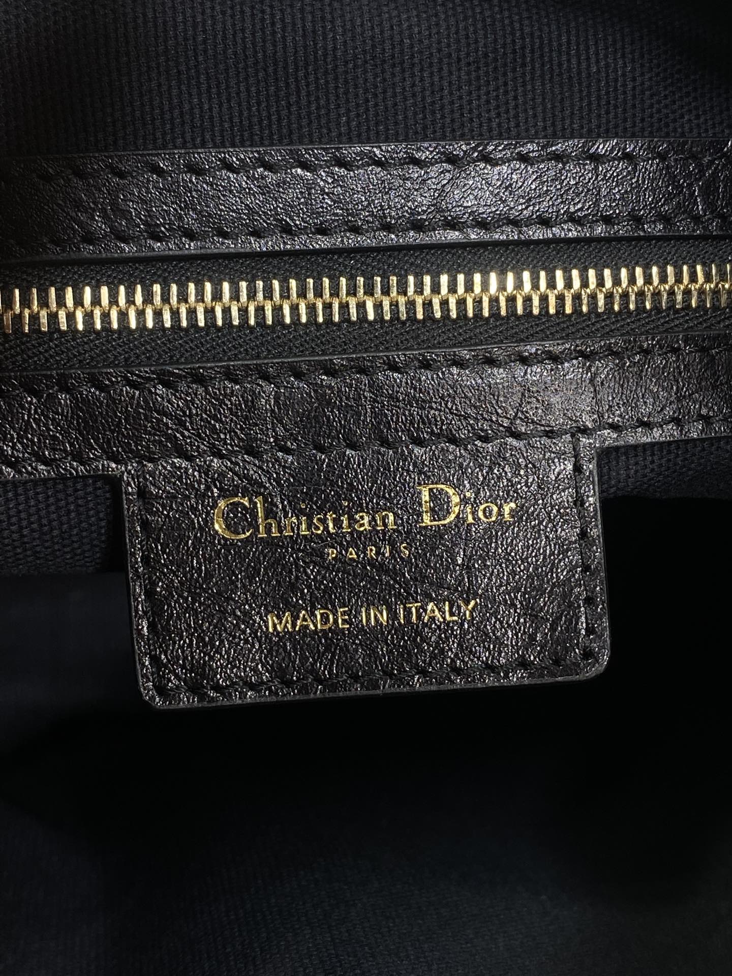 Black leather Dior tag with gold lettering and 'MADE IN ITALY' stamp