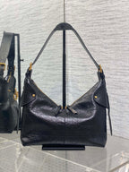 Black leather hobo bag with two shoulder straps and gold-tone hardware, side view