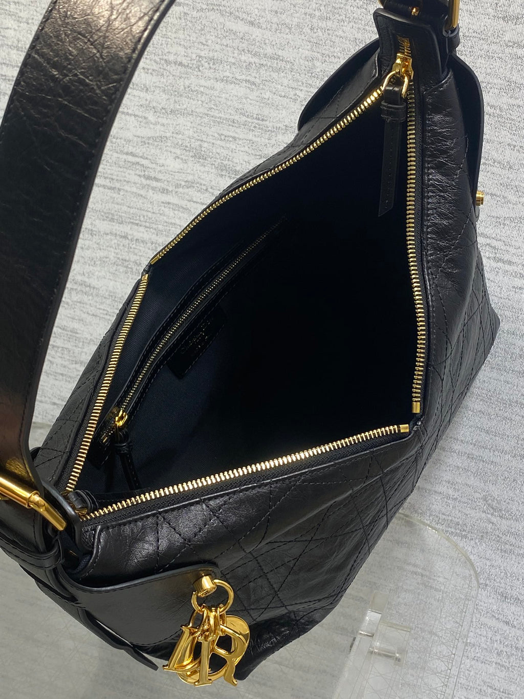 Black leather bag interior with gold zipper track and dangling hardware charm