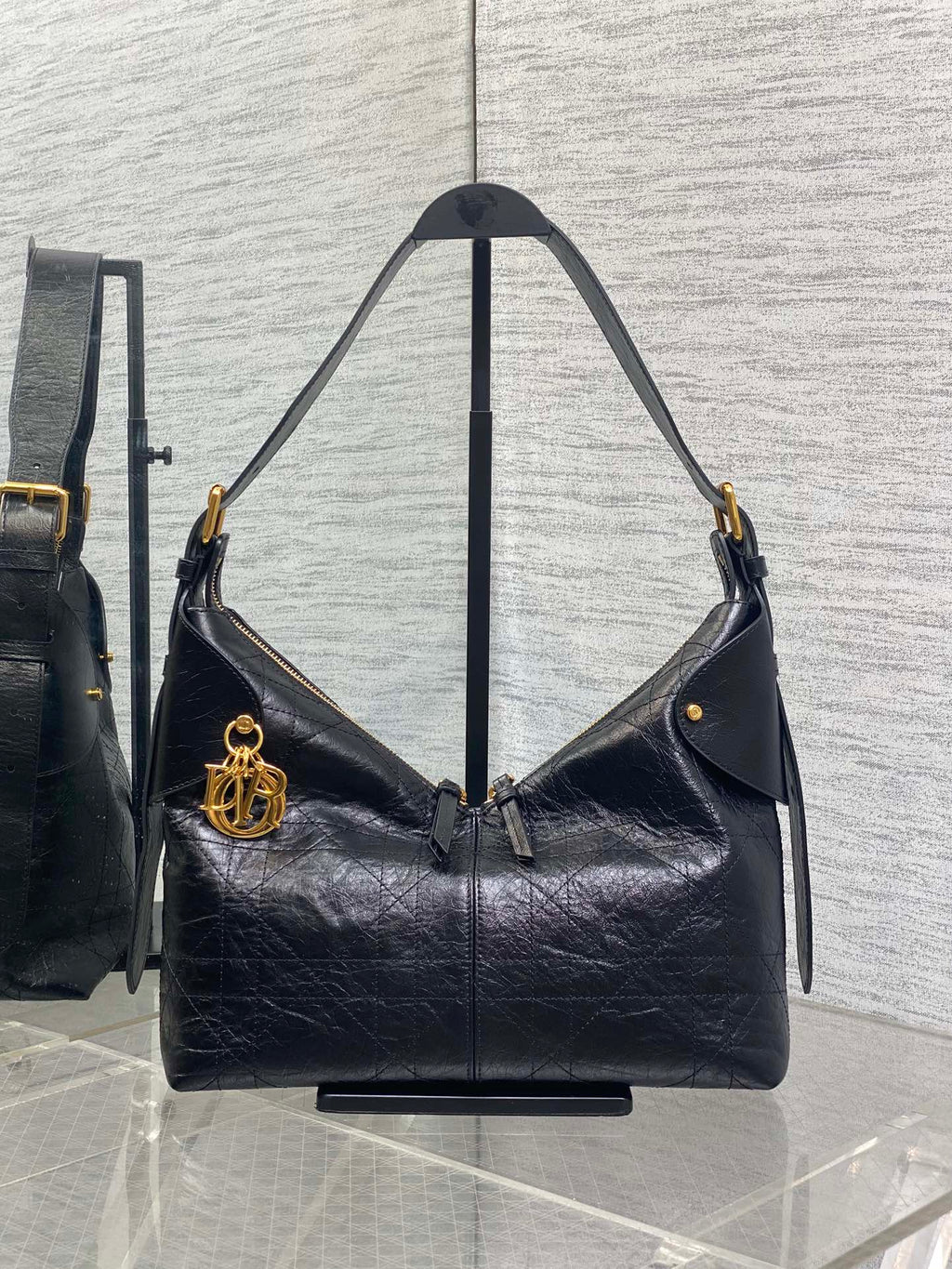 Black leather hobo bag with top handles and gold-tone hardware, front flap detail