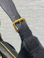 Black leather strap with gold buckle hardware and stitched fastening tab