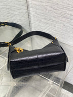 Black leather shoulder bag with short handles and gold-tone logo charm