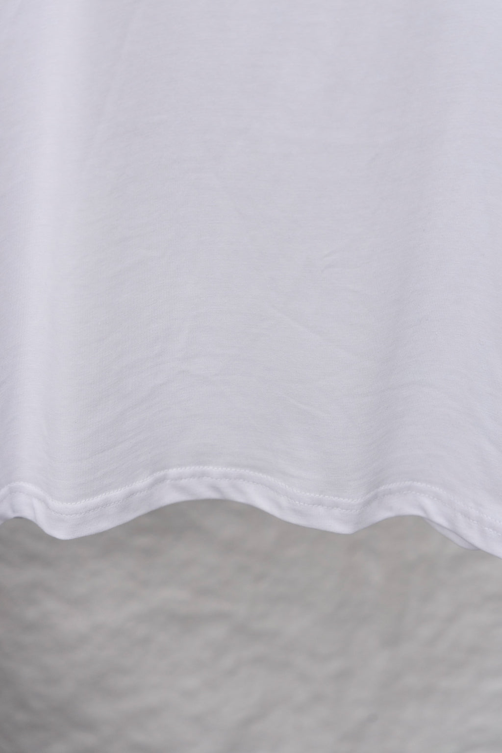 White T-shirt lower hem with curved stitching