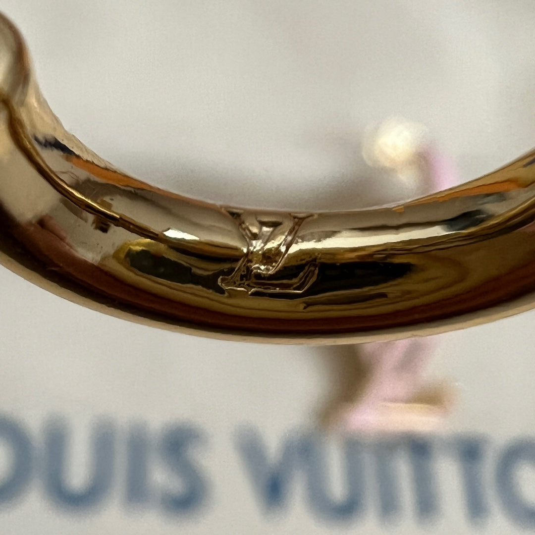 Gold-tone metal bracelet cuff close-up with reflective surface